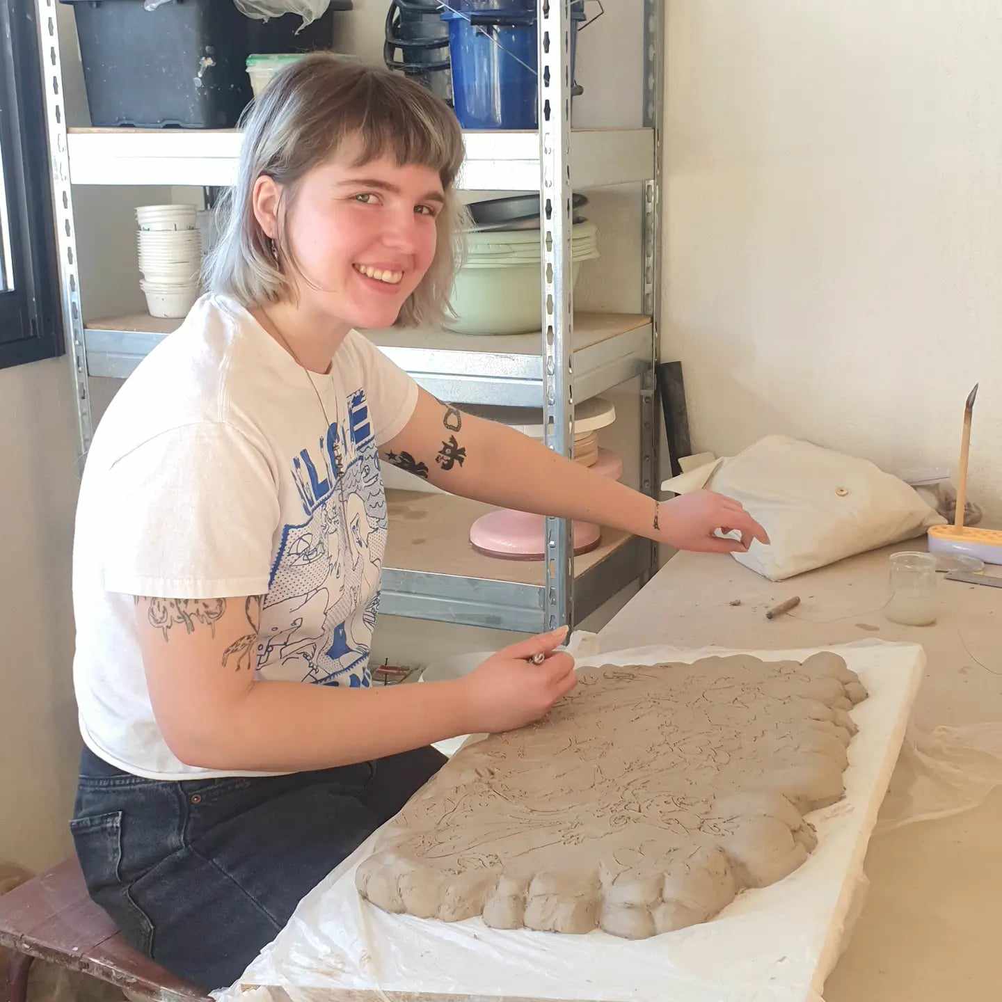 Student shaping clay on a pottery wheel